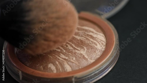 make-up artist applies makeup on a large fluffy brush. Facial sculptor close-up. Beauty background with working tools