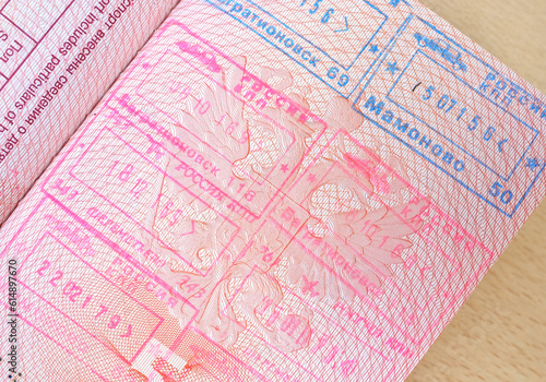 close up part of pages of foreign passport with foreign visas  border stamps  permits to enter countries  concept of traveling around the world  traveler s travel document