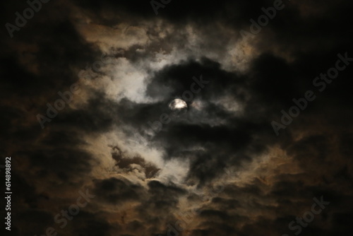 A mística lua cheia se esconde por trás das suaves nuvens, em um espetáculo celestial.