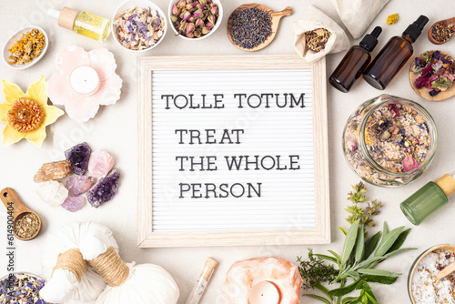 Letter board with text Tolle totum meaning treat the whole person in latin. Naturopatical principle. Botanical blends, herbs, essencial oils for naturopathy. Natural remedy, herbal medicine concept