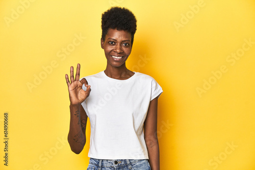 Elegant African woman, short hair, white tank top, Elegant African woman, short hair, white tank topcheerful and confident showing ok gesture.