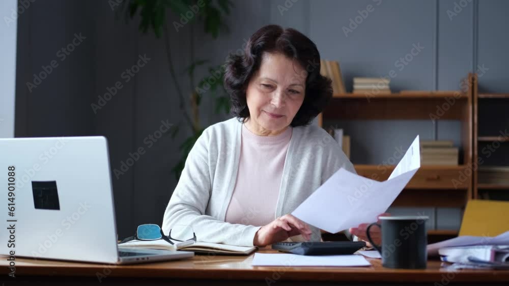 Middle aged senior woman sit with laptop and paper document. Pensive older mature lady reading paper bill pay online at home managing bank finances calculating taxes planning loan debt pension payment Middle aged senior woman sit with laptop and paper document. Pensive older mature lady reading paper bill pay online at home managing bank finances calculating taxes planning loan debt pension payment