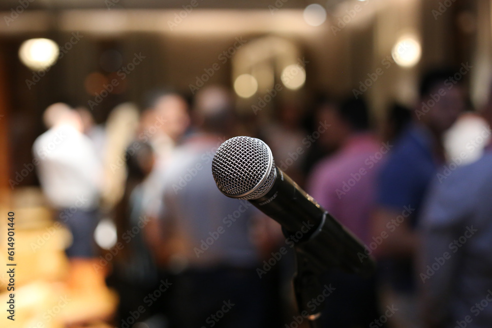 Φωτογραφία Um microfone posicionado em primeiro plano, aguardando ansiosamente o início do show em um evento social