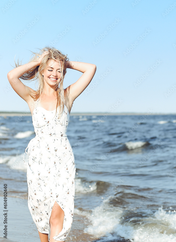 Happy blonde beautiful woman having fun on ocean beach while dancing in waves Happy blonde beautiful woman having fun on ocean beach while dancing in waves