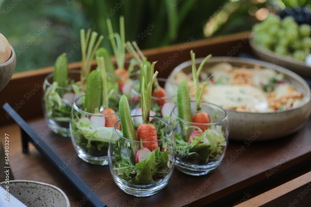 Uma salada fresca e colorida, cuidadosamente servida em potes de vidro, destacando-se pela presença das mini cenouras com seus talos verdes intactos. Um toque especial em um evento social chique, dura Uma salada fresca e colorida, cuidadosamente servida em potes de vidro, destacando-se pela presença das mini cenouras com seus talos verdes intactos. Um toque especial em um evento social chique, dura