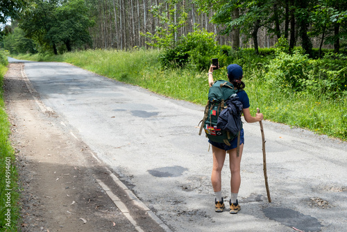 Young woman pilgrim taking a selfie on a trail of the way of saint james. Camino de Santiago
