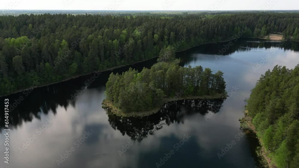An aerial shot of the small islet on the lake forest with the trees surrounding on the area in Estonia An aerial shot of the small islet on the lake forest with the trees surrounding on the area in Estonia