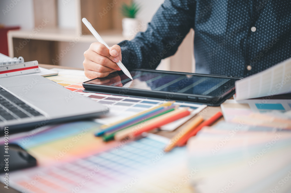 Graphic designer architects who work with laptops and color comparison tables for design work.. Graphic designer architects who work with laptops and color comparison tables for design work..