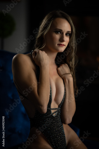 female posing on a blue couch by a fireplace © Promo Model Studio
