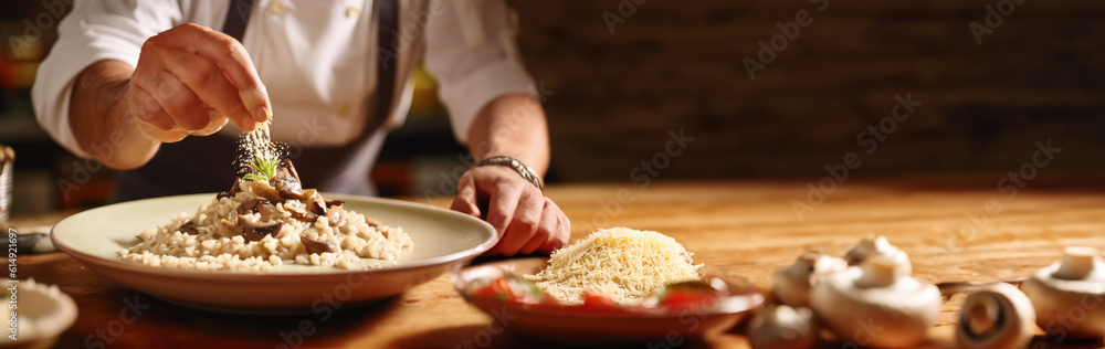 Creamy Mushroom Risotto. Chef sprinkling Parmesan cheese on a mushroom risotto dish on a wooden table. Copy space. Gastronomy concept. AI Generative