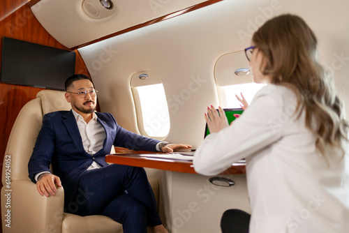 Obraz na plátně successful asian businessman in suit at meeting with businesswoman partner in pr