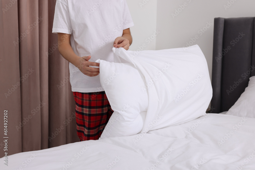 Boy changing pillowcase in bedroom, closeup. Domestic chores Boy changing pillowcase in bedroom, closeup. Domestic chores