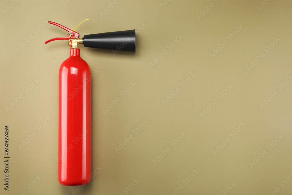 Fire extinguisher on light brown background, top view. Space for text Fire extinguisher on light brown background, top view. Space for text