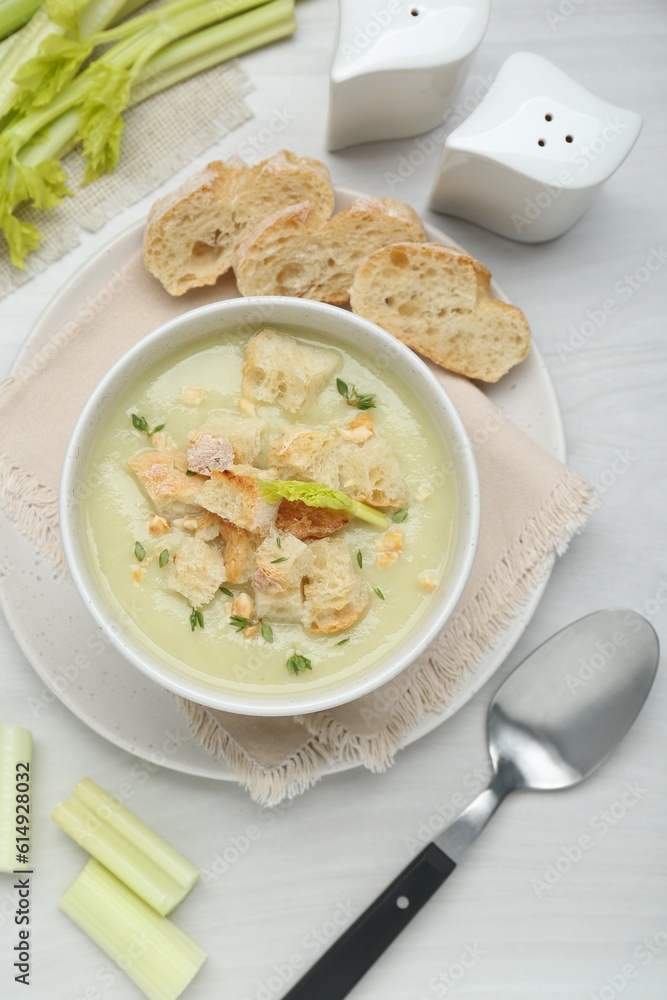 Delicious celery soup served on white wooden table, flat lay