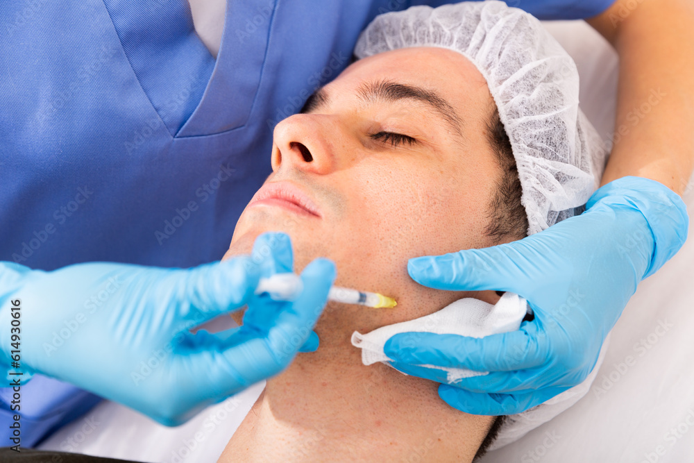 Φωτογραφία Young man caring of his skin, getting injection for face skin tightening at aest