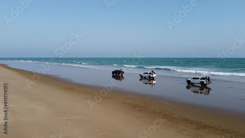 Aerial drone shot over three vehicle driving on the Sapat beach, buji koh in Balochistan during evening time. photo