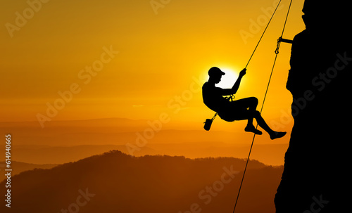 Young man rock climber silhouette, adventure experiences concept © mbolina