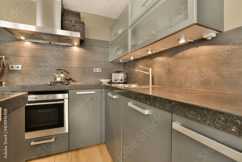 a modern kitchen with granite counter tops and stainless steel appliances on the wall behind it is a wood floor that has been installed