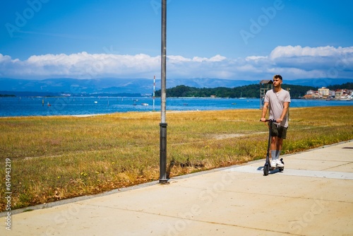 Man on a scooter along a seafront promenade photo