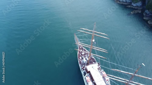 A large sail powered cruise ship is arriving in port, followed by a tug with rolling hills in the background. Panning round to reveal Dartmouth, Devon, United Kingdom. photo