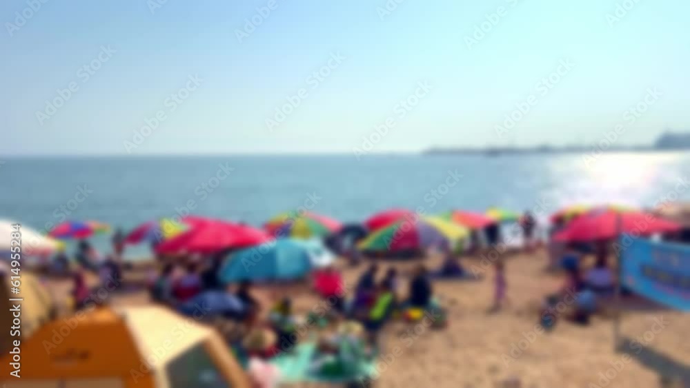 Blurred, people on vacation with parasols and tents on the beach
Blurred, people on vacation with parasols and tents on the beach