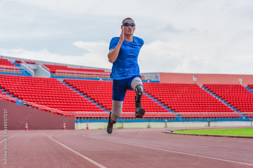 Obraz premium Asian male athlete with prosthetics runs at full speed, demonstrating a powerful practice on stadium track