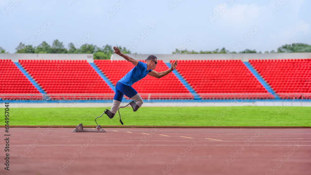 Obraz premium Asian male athlete, prosthetics user, sprints off from block start, powering his practice run on stadium track