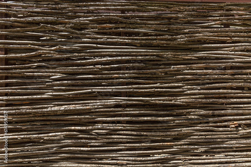 Fence made of dry brown rods. Background, space for text. Close-up.