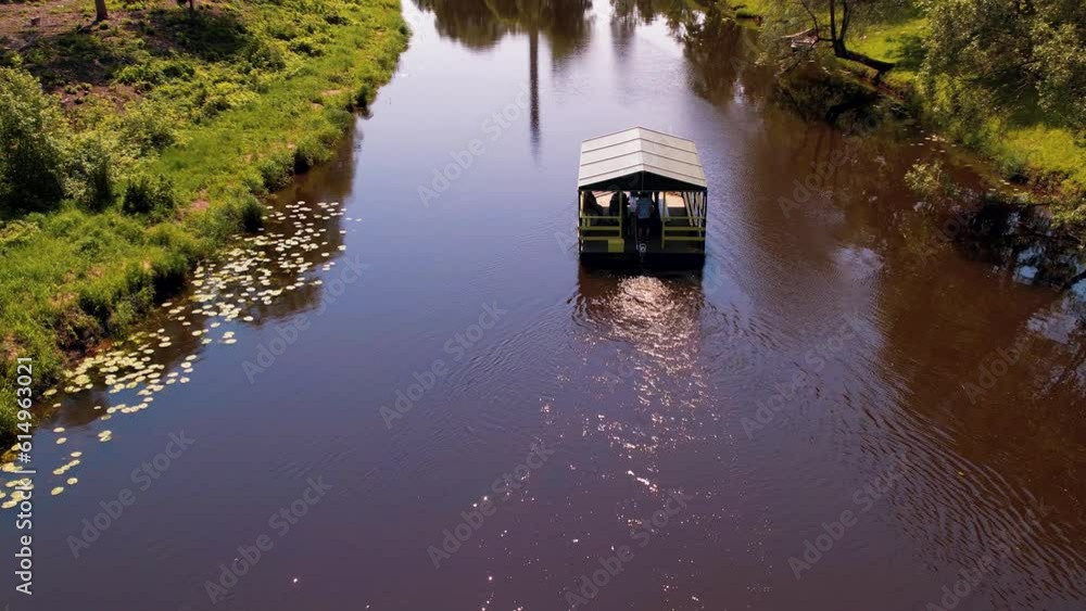 A raft with a roof. A raft floats in the river Salac. A raft with people floats down the river A raft with a roof. A raft floats in the river Salac. A raft with people floats down the river