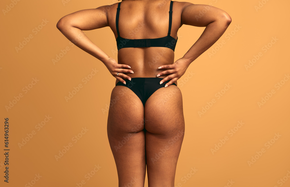 Crop anonymous woman in lingerie standing in studio with hands on waist