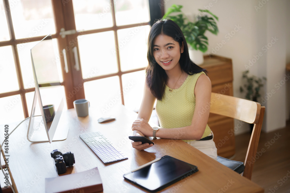 Asian creative woman sitting and working on computer creating an artwork.. Asian creative woman sitting and working on computer creating an artwork..