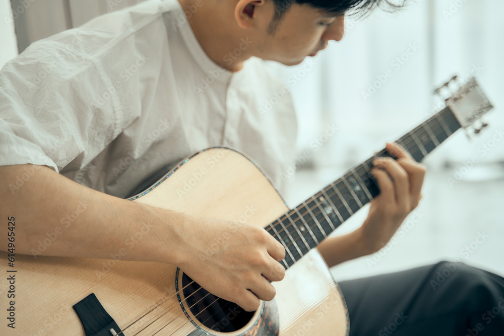 Fototapeta premium young male musician playing acoustic guitar , Close up classic guitar , finger style . happy mood white background with copy space can use for music school.
