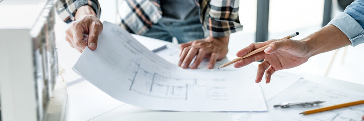 Architects interior designer hands working with Blue prints and documents for a home renovation for house design.