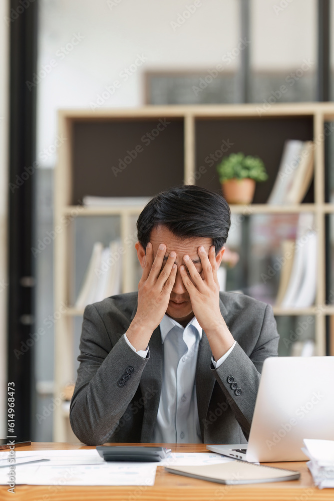 Financier a asian man feel stress with works, uses a laptop, makes a report to a finance company. Accounting and financial concept Financier a asian man feel stress with works, uses a laptop, makes a report to a finance company. Accounting and financial concept