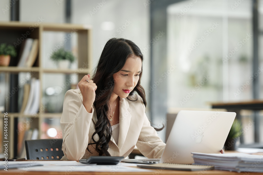 Financier a asian woman feel stress with works, uses a laptop, makes a report to a finance company. Accounting and financial concept Financier a asian woman feel stress with works, uses a laptop, makes a report to a finance company. Accounting and financial concept