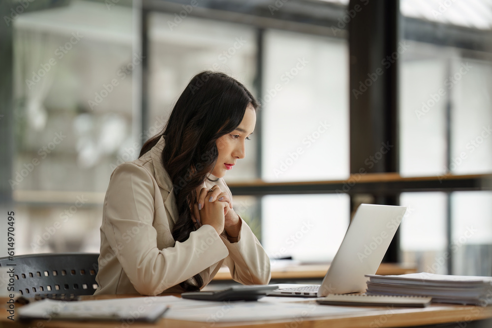 Financier a asian woman feel stress with works, uses a laptop, makes a report to a finance company. Accounting and financial concept Financier a asian woman feel stress with works, uses a laptop, makes a report to a finance company. Accounting and financial concept