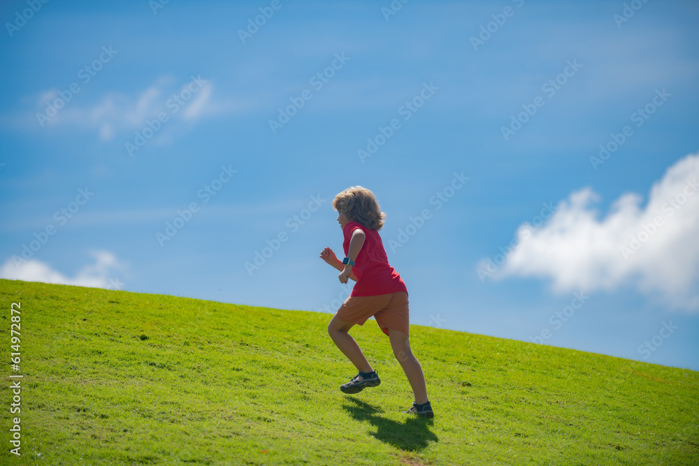 Cute boy running across grass and summer sky. Child runner running in the nature. Morning jogging. Active healthy kids lifestyle. Cute boy running across grass and summer sky. Child runner running in the nature. Morning jogging. Active healthy kids lifestyle.