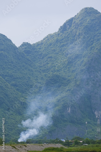 Cooking smoke from a house with a mountain in the background