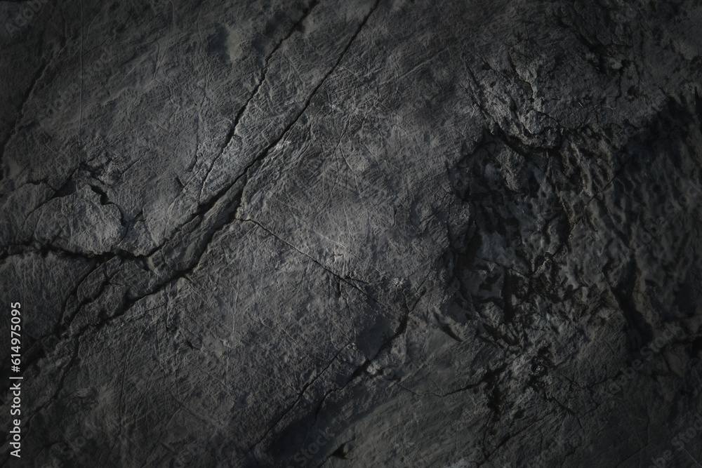 Dark rock texture background.Dark aged and cracked of black stone.