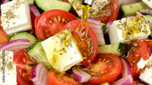 Pouring olive oil on greek salad. Fresh vegetable salad, mediterranean cuisine