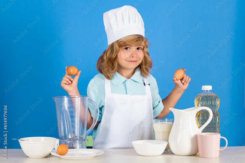 Child chef hold eggs dressed cook baker apron and chef hat isolated on studio background. Healthy nutrition kids food. Child chef hold eggs dressed cook baker apron and chef hat isolated on studio background. Healthy nutrition kids food.