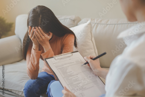 Psychology, depression. Sad, suffering asian young woman, girl consulting with psychologist, psychiatrist while patient counseling mental with doctor hand taking notes at clinic. Encouraging, therapy. photo