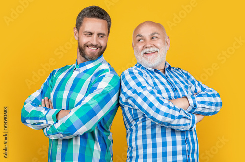 cheerful two generation family men isolated on yellow. two generation family men in studio © be free