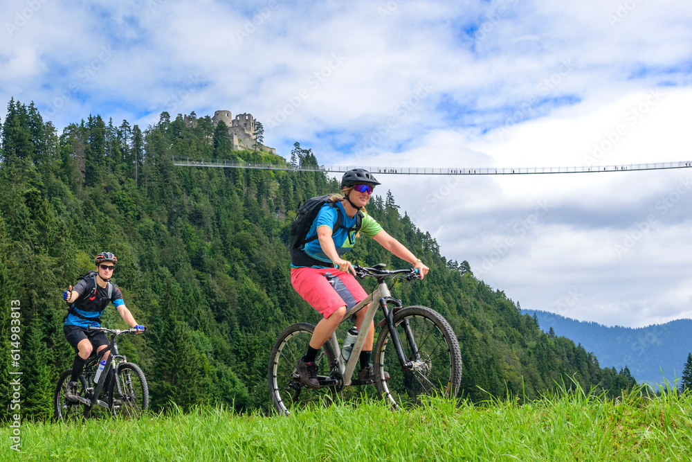 Zwei Mountainbiker vor der Burgruine Ehrenbergbei Reutte  in Tirol