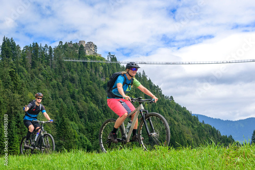 Zwei Mountainbiker vor der Burgruine Ehrenbergbei Reutte in Tirol