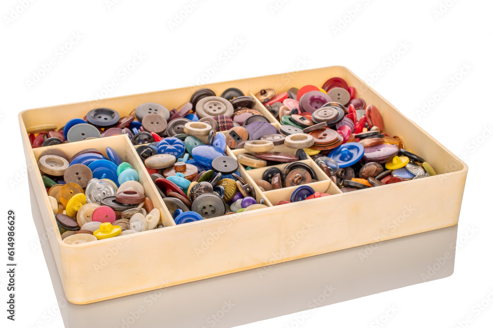 Many buttons in plastic container, macro isolated on white background. Many buttons in plastic container, macro isolated on white background.