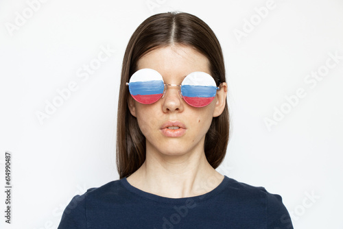 The flag of Russia on the glasses of a girl on a white background, blind and deceived by Russian propaganda, does not see anything