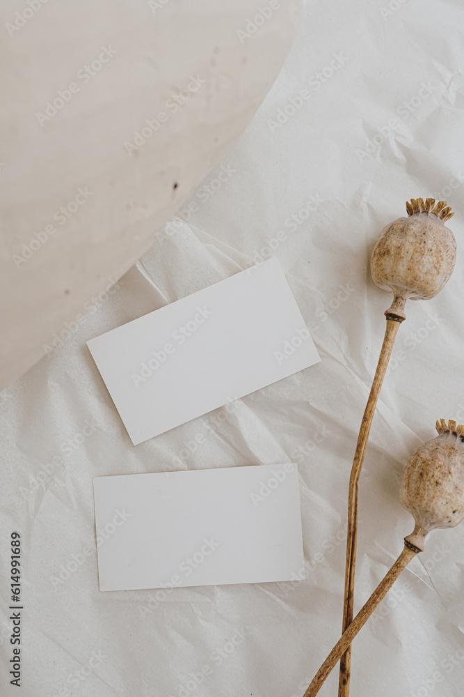 Flat lay blank card sheets, dried poppy stem, clay jar on white crumpled cloth. Top view aesthetic mock up with empty free copy space Flat lay blank card sheets, dried poppy stem, clay jar on white crumpled cloth. Top view aesthetic mock up with empty free copy space
