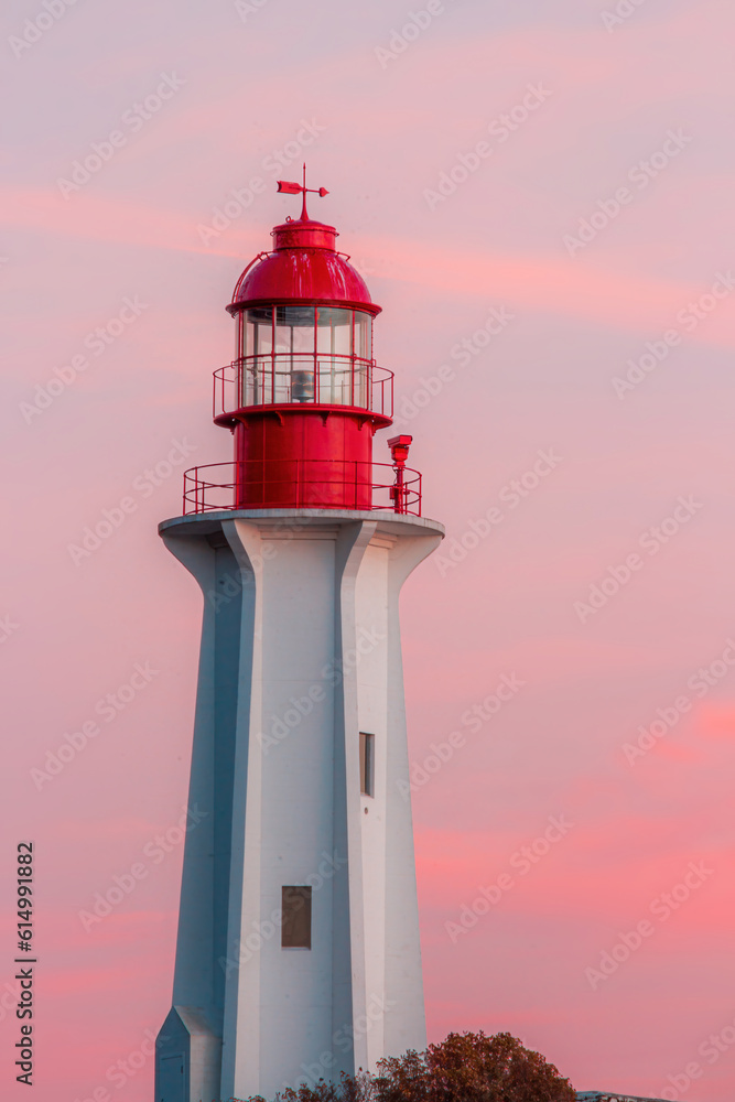 Lighthouse with a red top during a purple sunset