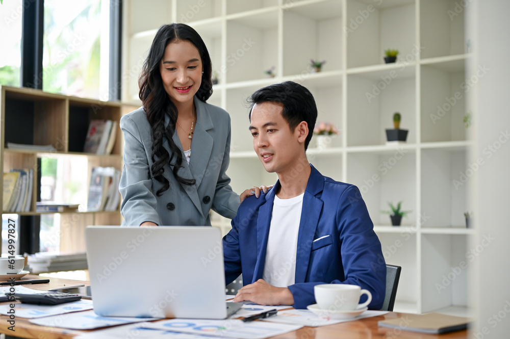 A female boss is training and briefing a male worker in the office on a new project. A female boss is training and briefing a male worker in the office on a new project.